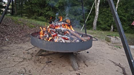 campfire grill or fire pit grill with burning wood in the firebox