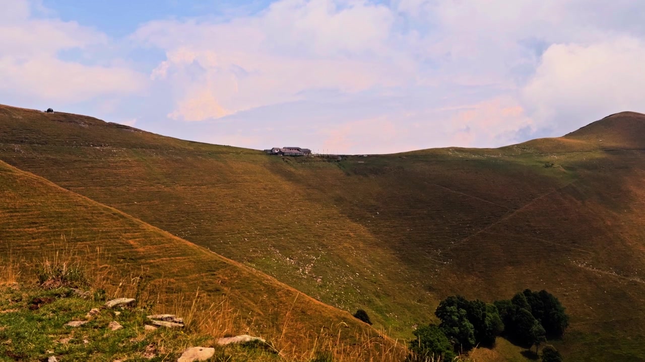 Splendido paesaggio montano in Lombardia, Italia, con un grande gregge di pecore che pascola sulle verdi colline sotto un cielo parzialmente nuvoloso