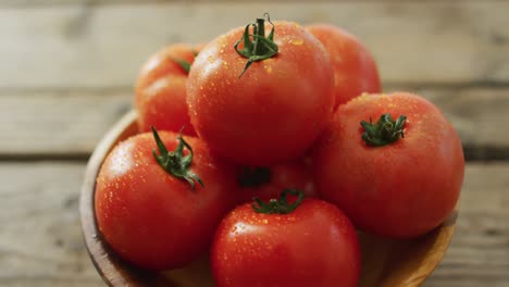 Vídeo-De-Cerca-De-Tomates-Frescos-En-Un-Recipiente-Sobre-Fondo-De-Madera