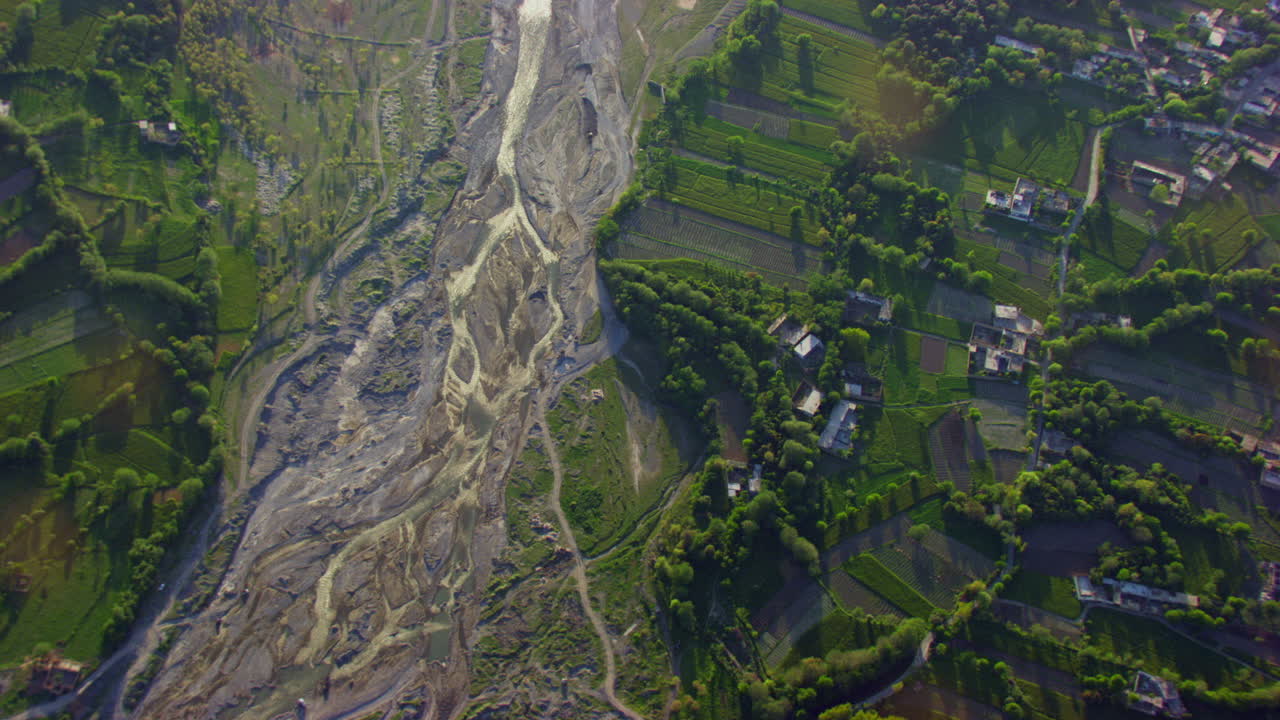 vista aérea de un río y un valle, árboles verdes, pasto y bosque con casas, la cámara está arriba en el río, escasez de agua en el río
