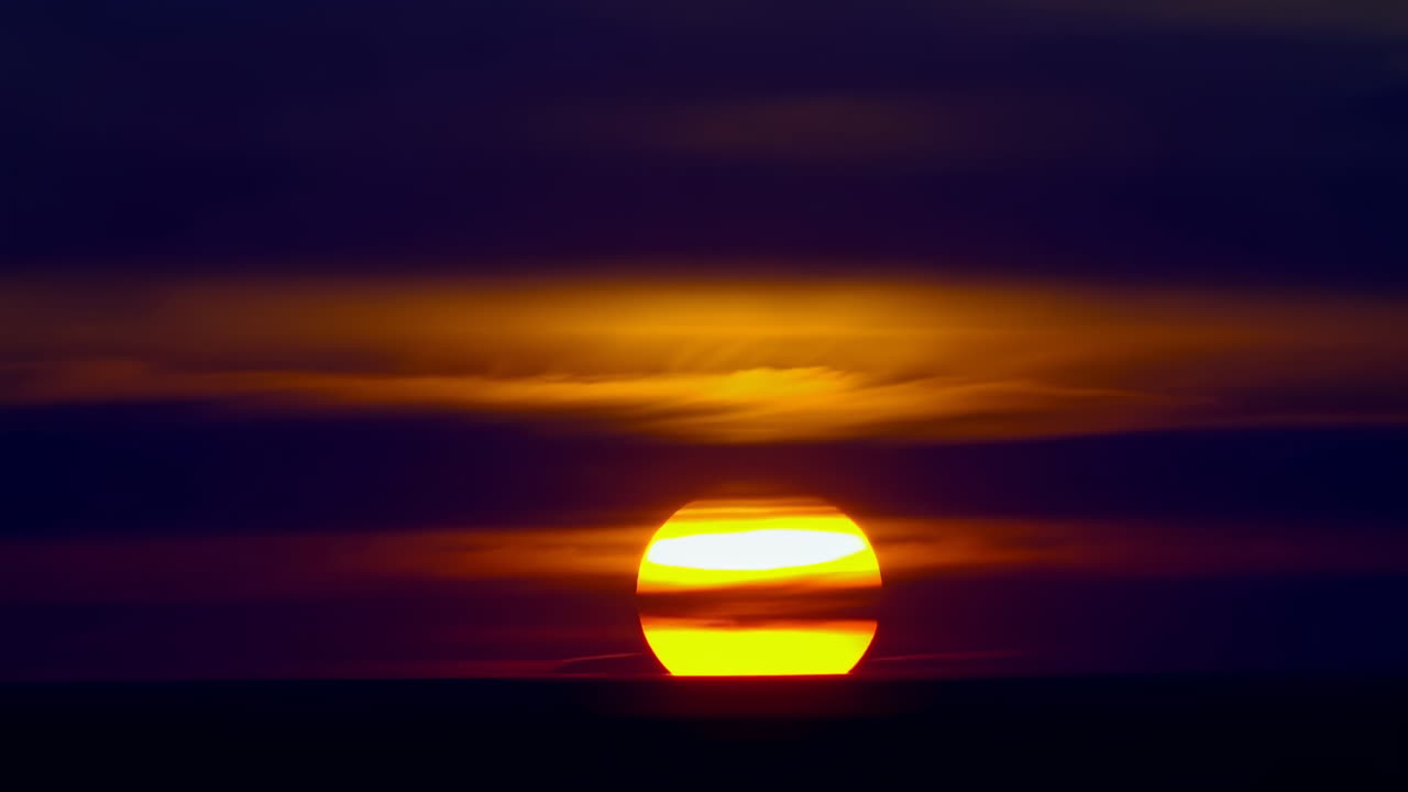 Aikaviivekuvaus elinvoimaisesta auringonnoususta horisontin yllä.
