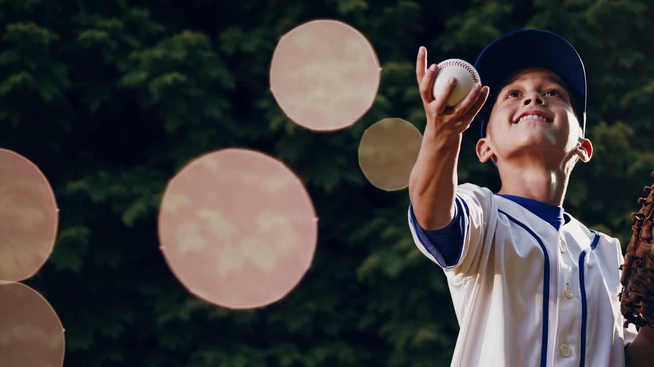 Inquadratura dal basso di un giovane giocatore di baseball che guarda in alto, con un guantone.