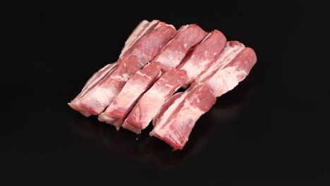 raw bacon, isolated on black. side view. loop motion. rotation 360.