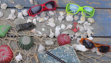 conchas marinas en un fondo azul. tiempo de viaje de verano. fondo de vacaciones en el mar con varias conchas, gafas de sol y cámara vintage. diseño de colocación. vista superior. colocación plana