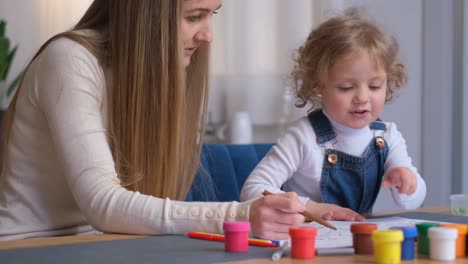 mother and child coloring together at a table