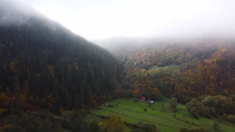 Foggy-view-of-the-traditional-countryside-of-Transylvania,-Romania,-early-morning,-autumn,-orbit-drone-shot