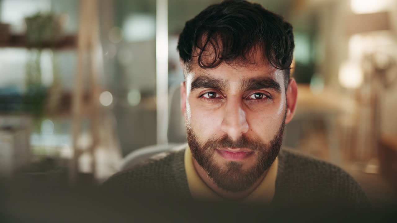 un hombre barbudo trabajando en un escritorio en una oficina