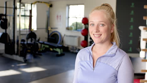 Smiling woman in gym during disability rehab session, wearing athletic wear, copy space
