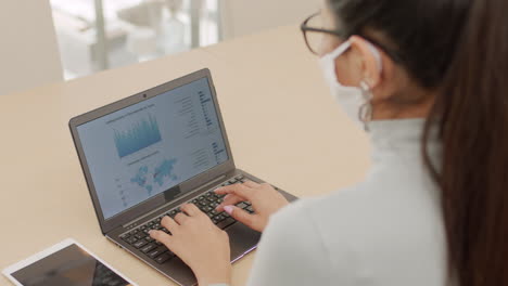 mujer escribiendo en laptop