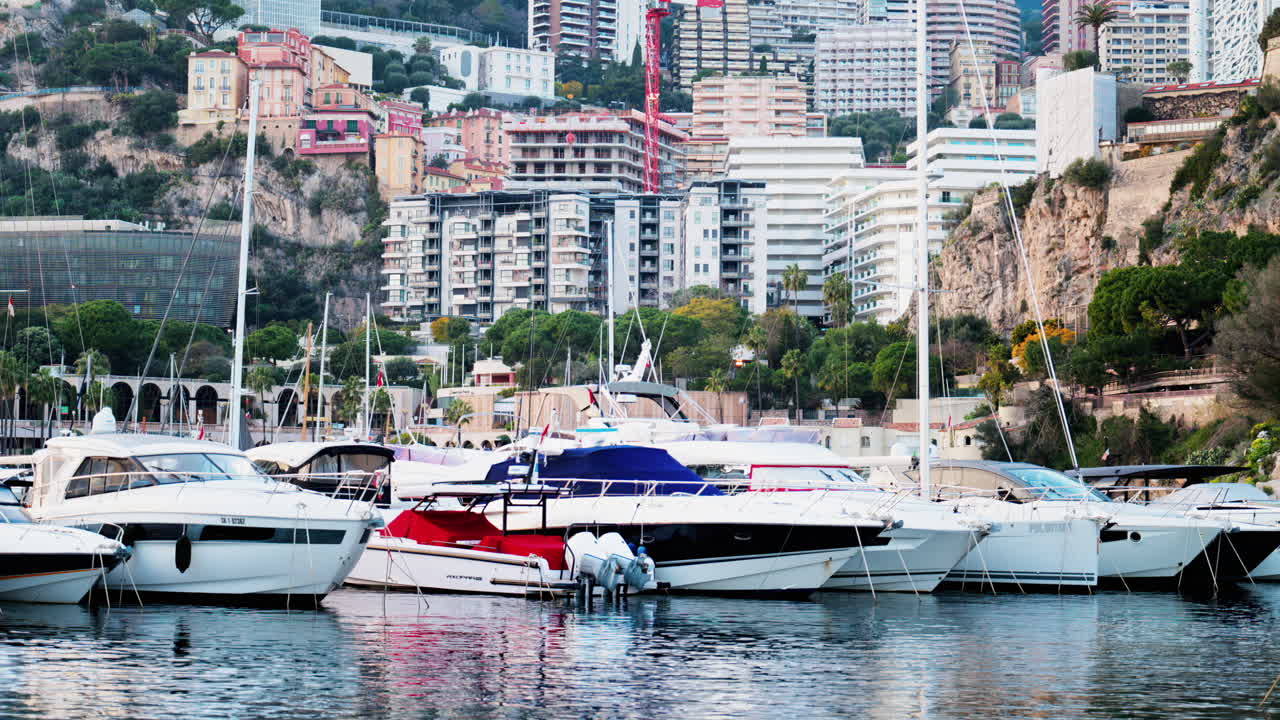 Vista delle barche ormeggiate nel porto turistico di Monaco con lo skyline della città sullo sfondo