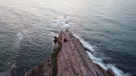 vista aérea panorámica de una pareja en los acantilados de zumaia, españa