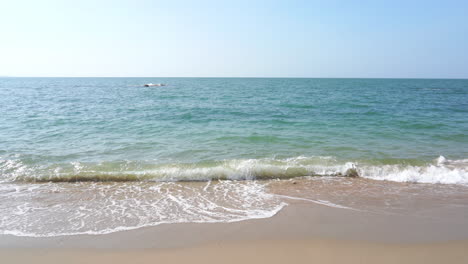 Waves-calmly-washing-up-onto-a-tropical-beach-on-an-island-in-Thailand