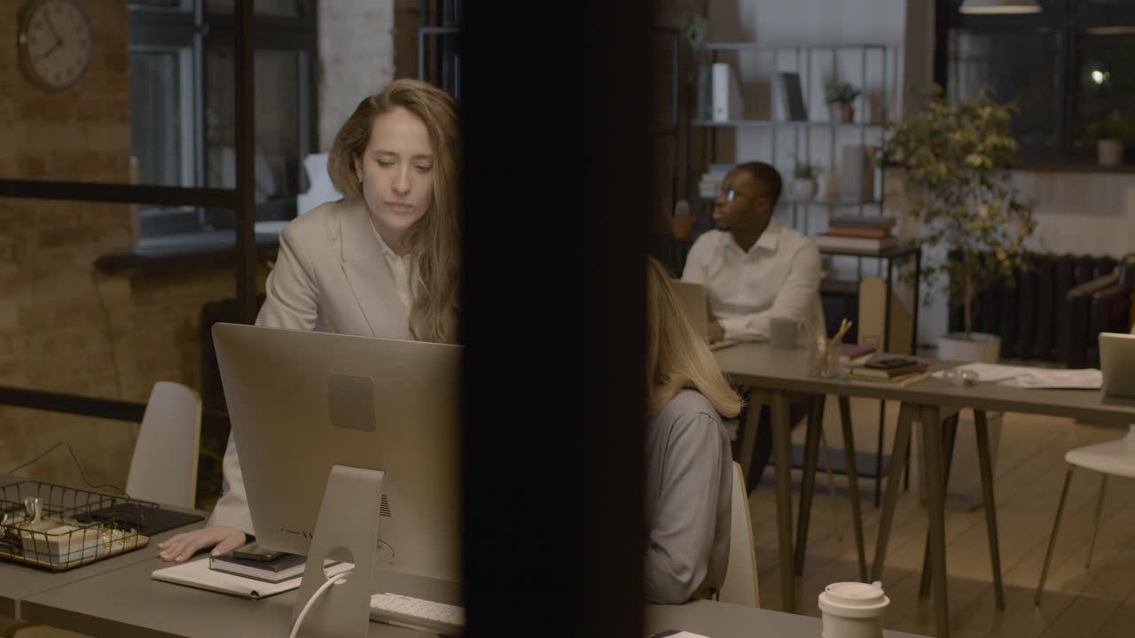 Two Female Employees Looking Something At Computer And Talking Together In The Office 1