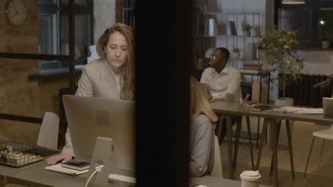 two female employees looking something at computer and talking together in the office 1