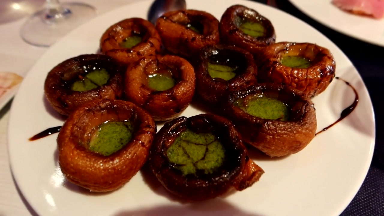 Primo piano su un piatto di funghi con salsa chimichurri. Deliziosa cucina spagnola.
