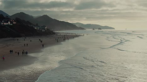 4k aerialoregon coast with people walking on the beach drone dolly in