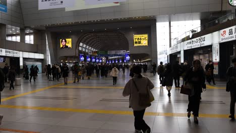 crowds moving through a busy train station