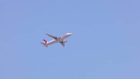 airplane in flight over clear blue sky