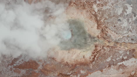 Overhead-view-of-Strokkur-geyser-in-Geysir-area-in-Iceland.-Top-down-view-of-steaming-geyser-in-Golden-circle-geothermal-area-in-icelandic-countryside.-Tourist-attraction.-Amazing-on-earth