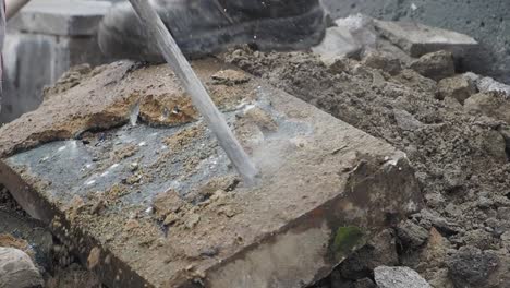 construction worker breaking concrete with a chisel