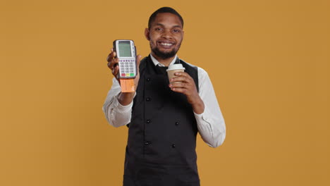 Professional-friendly-waiter-showing-the-pos-terminal-with-a-credit-card