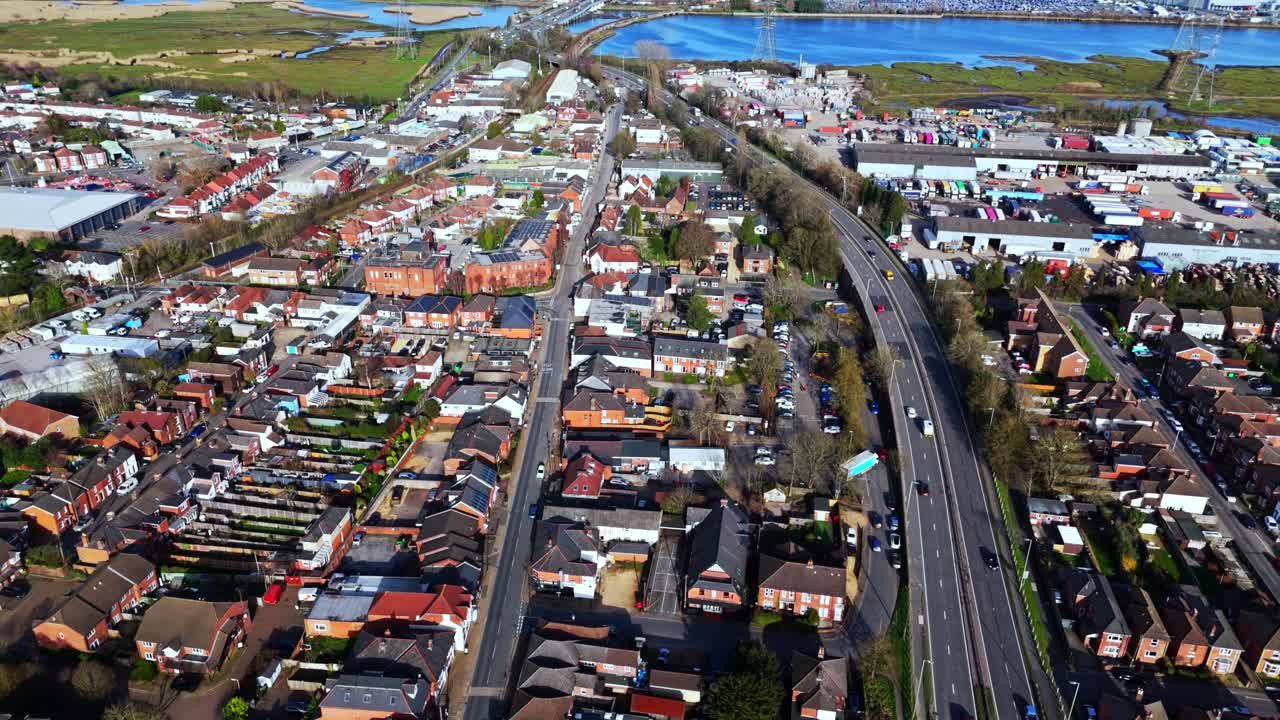 Luftpanoramaoptagelse over Totton-forstaden vest for floden i Southampton, England, med biler, der kører på de travle veje, og sollys, der reflekteres på det blå flodvand med både på den om vinteren.