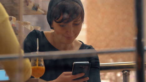 Mujeres-Atraídas-Por-Los-Teléfonos-Móviles-Durante-Una-Reunión-En-Un-Café