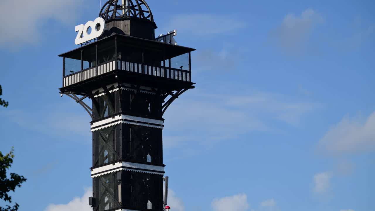 Iconic zoo observation tower flying the flag of Denmark on a clear day. Copenhagen