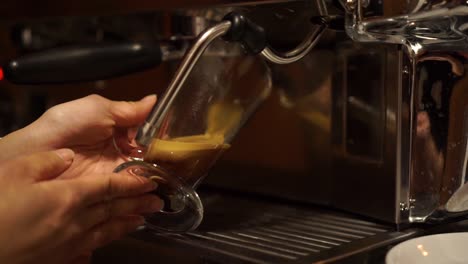 cámara lenta - máquina de café prepara espresso en café de vidrio largo - cerrar