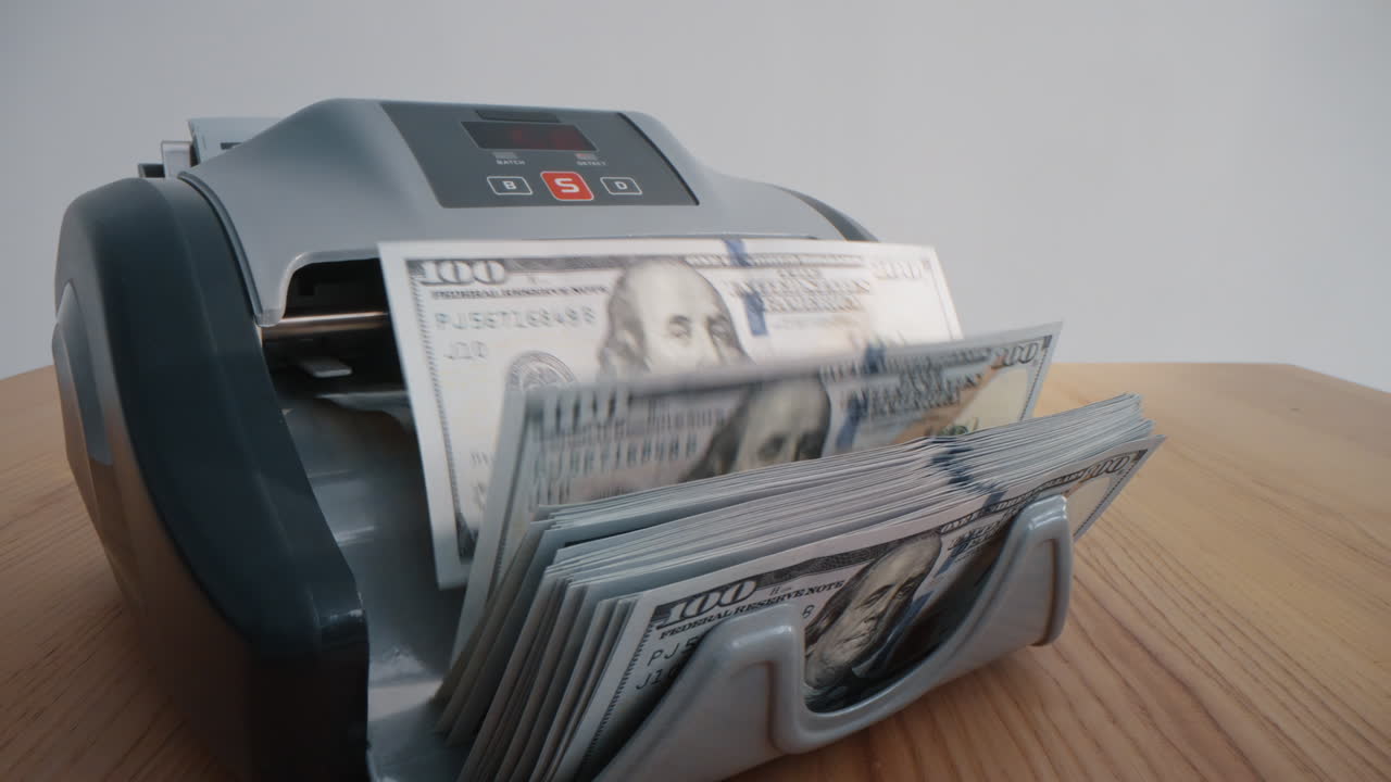 Primer plano de máquina contando dólares en interiores. Billetes de dinero para cambio de divisas