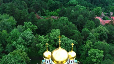 Close-aerial-view-of-the-memorial-church-Birth-of-Christ-near-Shipka,-Bulgaria-surrounded-by-green-trees-in-the-summer