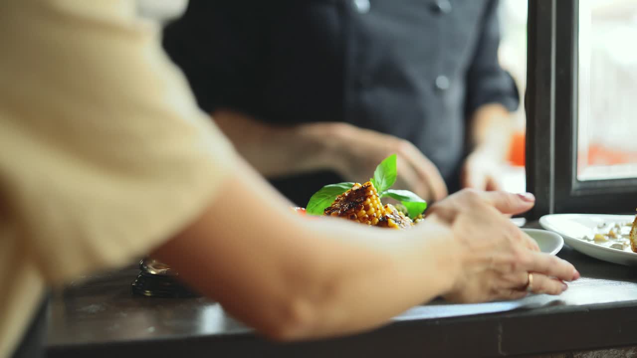 Chef presents a new dish. Grilled vegetables are served on a white plate.