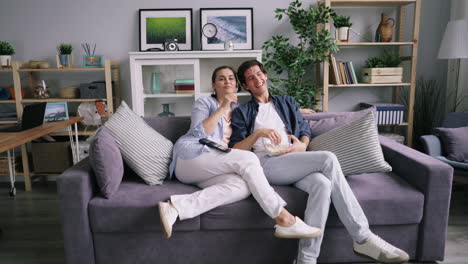 pareja viendo televisión y comiendo palomitas de maíz