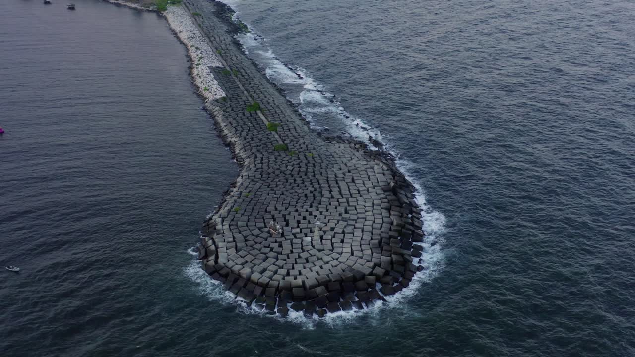 vista superior escénica del embarcadero rocoso de piedra larga en el agua azul del océano y las olas rompiendo en tierra, sobre la antena del círculo