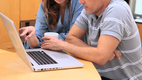 una pareja hablando de una computadora portátil.