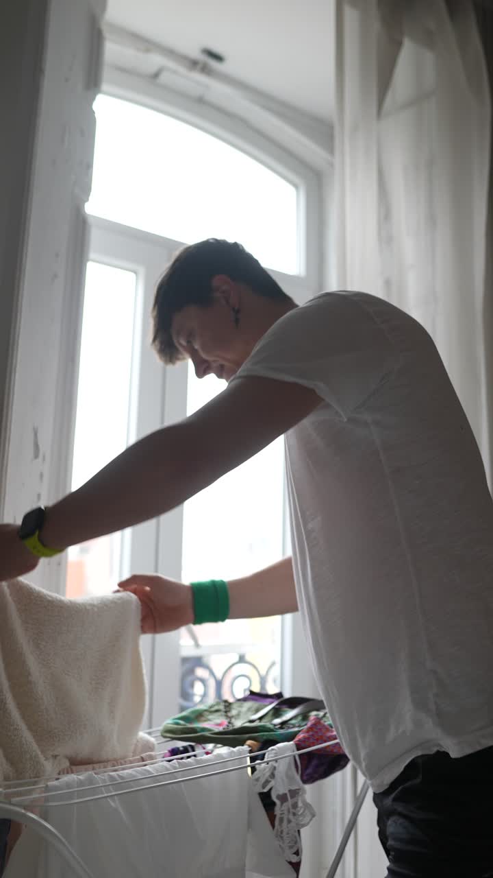 Person Drying Clothes by the Window