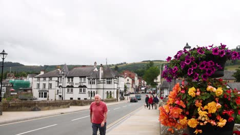 man walking past flowers on wrexham street