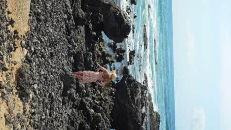 Slim-attractive-woman-admires-seascape-and-rocky-coast,-back-view