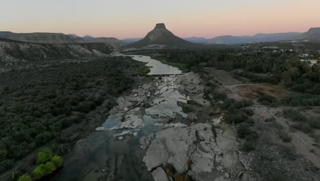 vista aérea moviéndose hacia adelante, vista panorámica del río en el lado de la montaña de la purísima baja california sur, méxico, montañas el pilón al fondo