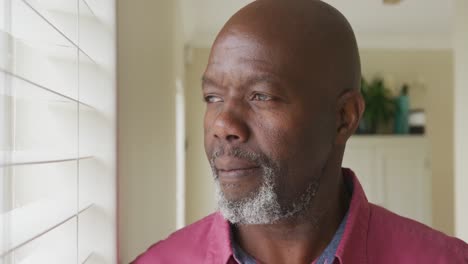senior african american man looking through window