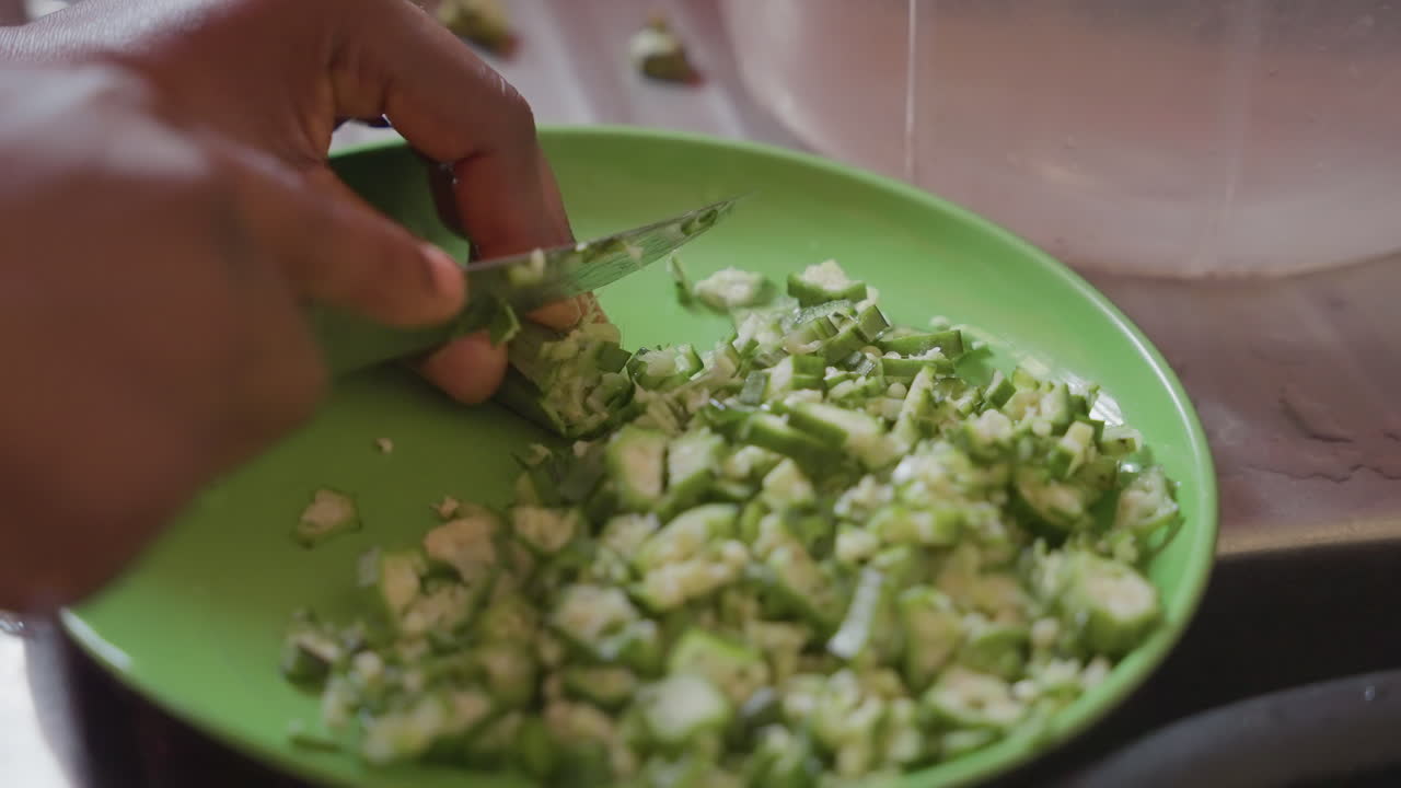 Hyggelig aften brugt på at skære moden avocado. Person skærer forsigtigt avocadostykker i skål derhjemme. Fredfyldt køkkenscenarie med nogen der tilbereder frisk grøntsagsrelish til familien