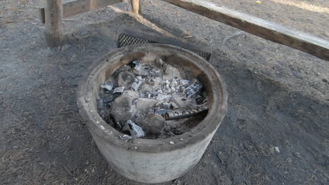 warm charcoal left in an empty windbreak after preparing food