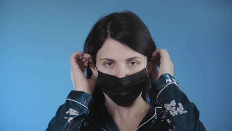 young caucasian beautiful woman put on protective face medical mask.female in pandemic epidemic of covid-19 coronavirus. 4k