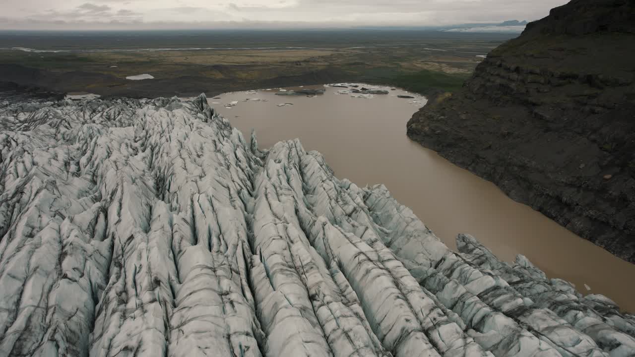 카메라가 4k 아래로 기울어져 있는 아이슬란드의 큰 빙하 위를 비행하는 드론