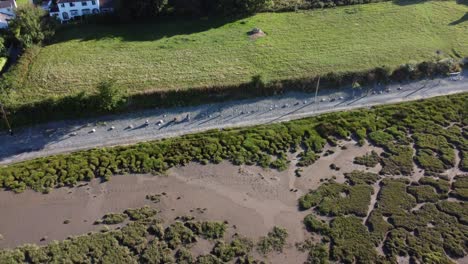 Vista-Aérea-Traeth-Coch-Pentraeth-Tierras-De-Cultivo-Campo-Con-Cabañas-De-Vacaciones-A-Lo-Largo-De-Salt-Marsh-Tiro-Inclinado-Hacia-Abajo