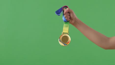 medalla de oro en la mano. fondo de pantalla verde