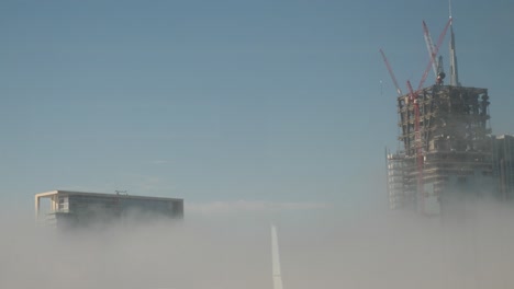 tres enormes rascacielos con vistas a las nubes o la niebla
