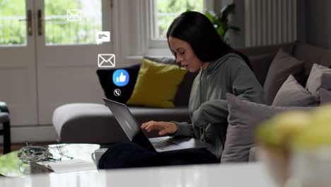 mujer estresada sentada en el sofá trabajando desde casa en una computadora portátil con emojis de gráficos de movimiento que muestran múltiples mensajes y notificaciones de redes sociales
