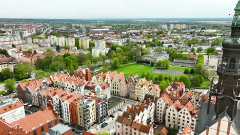 an aerial the majestic spire of a cathedral towering over the quaint and colorful townhouses of a vibrant city