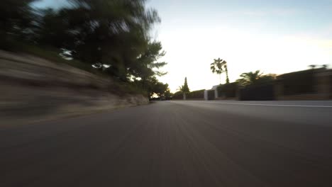 vista pov desde el coche trasero acelerando a lo largo de la carretera durante la puesta de sol, perspectiva de ángulo bajo